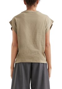 T-shirt en coton kaki avec des manches courtes roulées et une coupe décontractée, présentant un col rond et une texture uni.