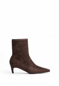 Bottine en daim marron avec un bout pointu et un talon fin. Présente une texture lisse et un design haut.