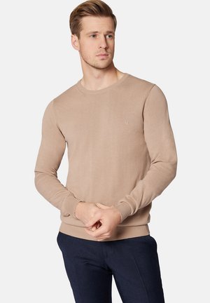 Beżowy sweter dzianinowy z okrągłym dekoltem i prążkowanymi mankietami. Prosty design z małym logo na piersi. Miękka tekstura i dopasowany krój.