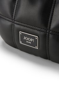 Črna usnjena torbica z gladko teksturo, šivanim detajlom in kovinsko ploščico z blagovno znamko "JOOP! JEANS".