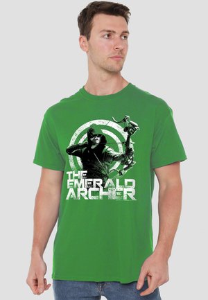 Man wearing green t-shirt with graphic of hooded archer aiming bow and text "The Emerald Archer" on front.