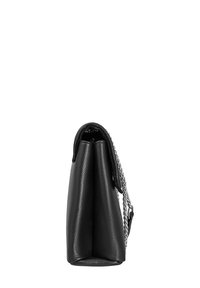 Borsa a spalla in pelle nera con una forma strutturata, caratterizzata da una superficie texturizzata e una tracolla in catena argentata su un lato.