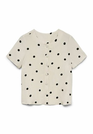 Blouse courte à manches courtes couleur crème avec des pois noirs et des boutons recouverts de tissu sur le devant, encolure arrondie.