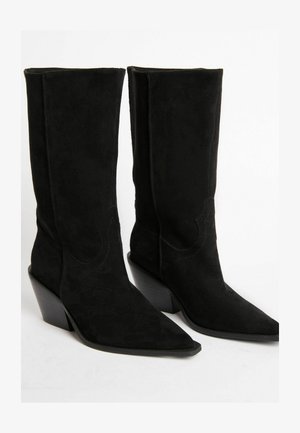 Mustad nahast pahkluusaapad, millel on terav nina, plokk-kreen ja dekoratiivne õmblusdetail varrel. Sile tekstuur ja liibuv disain.