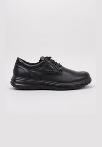Zapato negro de cuero con cordones, con cuello acolchado y suela texturizada, diseñado para la comodidad y para uso casual o formal.