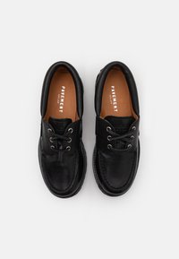 Black leather shoes featuring a rounded toe, lace-up design, contrasting brown interior, stitched accents, and metallic eyelets.