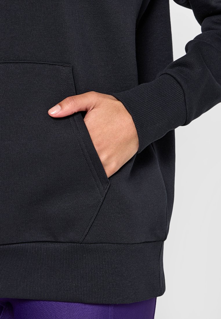 Sweatshirt noir avec poche kangourou, poignets et ourlet côtelés. Le tissu semble doux avec une texture lisse. Main partiellement dans la poche.