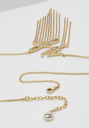 Collier en or avec un pendentif en écriture cursive incrusté de petits cristaux clairs et un fermoir de chaîne ajustable avec une petite médaille ronde.