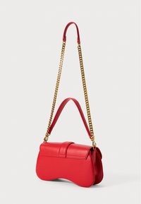 Sac à main en cuir rouge avec une forme incurvée, doté d'une bandoulière en chaîne dorée et d'une poignée assortie. Texture lisse avec un minimum de détails.
