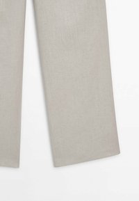 Pantalon beige clair à jambe droite avec un tissu subtilement texturé, présenté à plat sur un fond blanc.