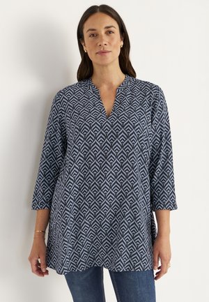 Marineblaue Tunika mit einem geometrischen weißen Muster, V-Ausschnitt und dreiviertel Ärmeln, aus leichtem Stoff.