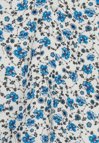 Tecido com padrão floral apresentando flores azuis com detalhes cinzentos sobre um fundo branco, adornado com botões circulares ao longo do centro.