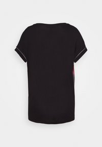 Sort kortærmet t-shirt med rund halsudskæring, blød tekstur og en let buet nederdel. Bagsiden viser en subtil designdetalje langs skuldersømmene.