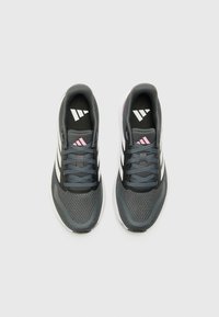Chaussures de sport avec un upper en textile gris, des rayures blanches, des lacets noirs et des accents roses. Elles disposent d'un col rembourré et d'une semelle texturée.