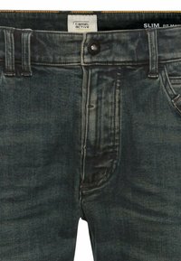Slim fit denim jeans in donkerblauw, met knoopsluiting, vijf zakken en subtiele vervaging op de stof voor textuur.
