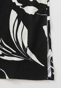 Schwarzer Stoff mit großem weißen Blumenmuster, glatte Textur und sauberen Kantenverzierungen. Das Design zeichnet sich durch kräftige, kontrastierende Farben aus.