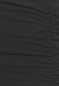 Gerimpeld zwart stof met een textuurafwerking, voorzien van golvende plooien en rimpelingen die een gelaagd uiterlijk creëren. Glad, rekbaar materiaal.