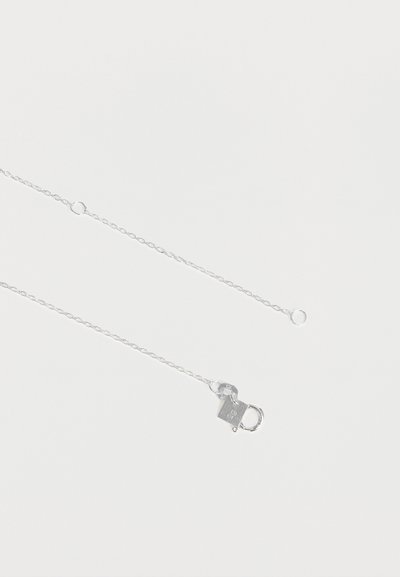 Collier délicat en chaîne argentée avec un fermoir mousqueton et un petit anneau pour la fixation, présenté sur fond blanc.
