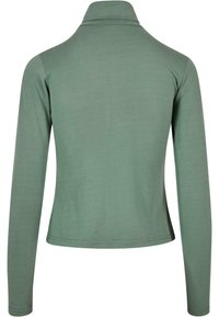 Bluză cu mânecă lungă dintr-un material verde moale, cu guler fals și design ajustat. Dispune de cusături plate și o textură netedă. Fără modele notabile.