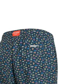 Costumi da bagno con sfondo blu navy, caratterizzati da un motivo di pesci colorati. Vita elastica con un'etichetta rossa e una piccola tasca posteriore.