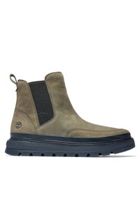 Bottines en daim marron avec des panneaux latéraux élastiques, une languette de traction et une semelle extérieure noire texturée en caoutchouc avec des crêtes pour une meilleure adhérence.