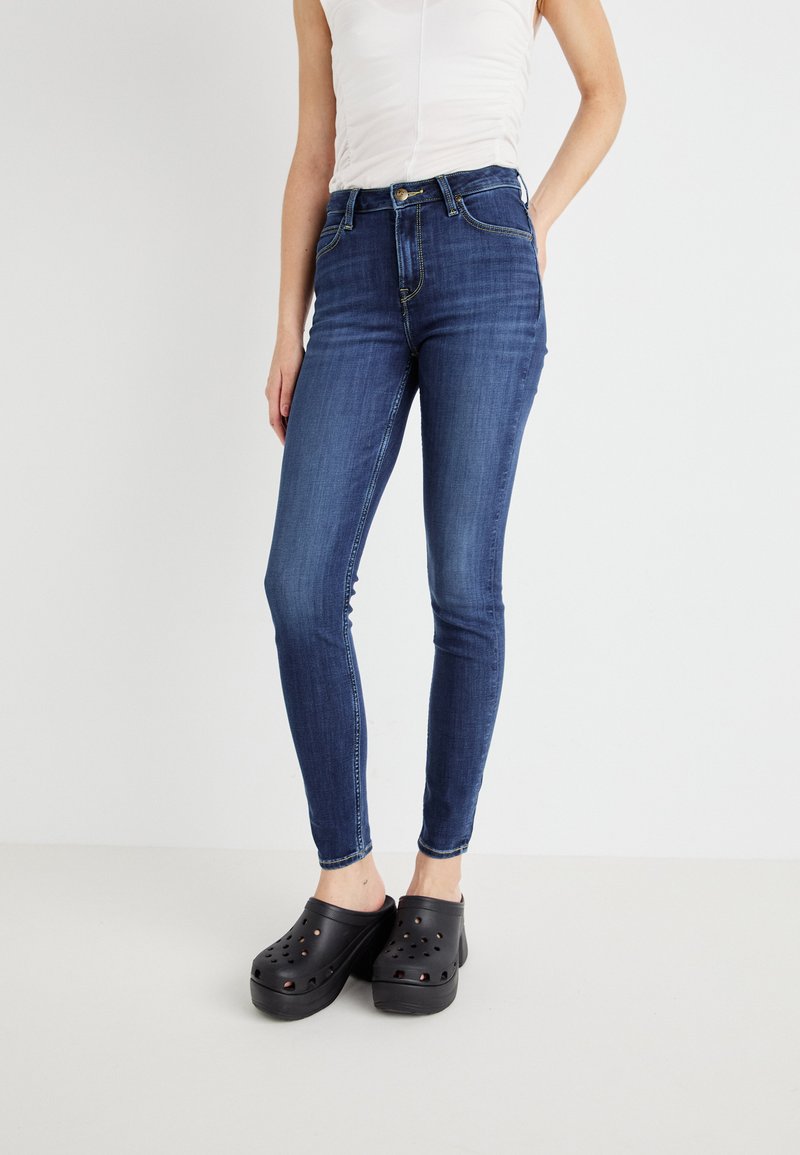 Smala jeans i mörkblå denim med hög midja, med en framknäppning och sömmar längs fickorna och sömmarna.