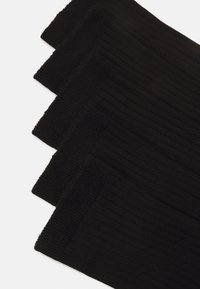 Black ribbed socks arranged in a stack, showcasing a textured pattern and consistent color with a soft, stretchy material.