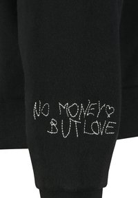Zwarte sweatshirt met witte geborduurde tekst "GEEN GELD MAAR LIEFDE," in een speelse, handgeschreven stijl. Zacht, gestructureerd materiaal.
