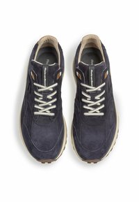 Tummansiniset nahkaiset lenkkikengät, joissa on teksturoitu pinta, kerma väriset nauhat, beigekenkäiset pohjat ja pienet ruskeat yksityiskohdat. Sisältää pehmustetun nilkka- ja kieliosan.