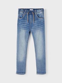 Jeans in denim azzurro chiaro con gamba affusolata, vita elastica, chiusura a coulisse e cinque tasche. Dettagli sbiaditi sulle cosce.