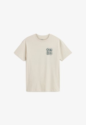 Světle béžové bavlněné tričko s kulatým výstřihem. Na levé části hrudi se nachází malý modrý grafický design. Krátké rukávy, volný střih.