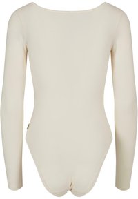 Bodysuit de manga larga en color beige, hecho de una tela suave y elástica. Presenta un escote en forma de escotadura y una silueta ajustada con un diseño minimalista.