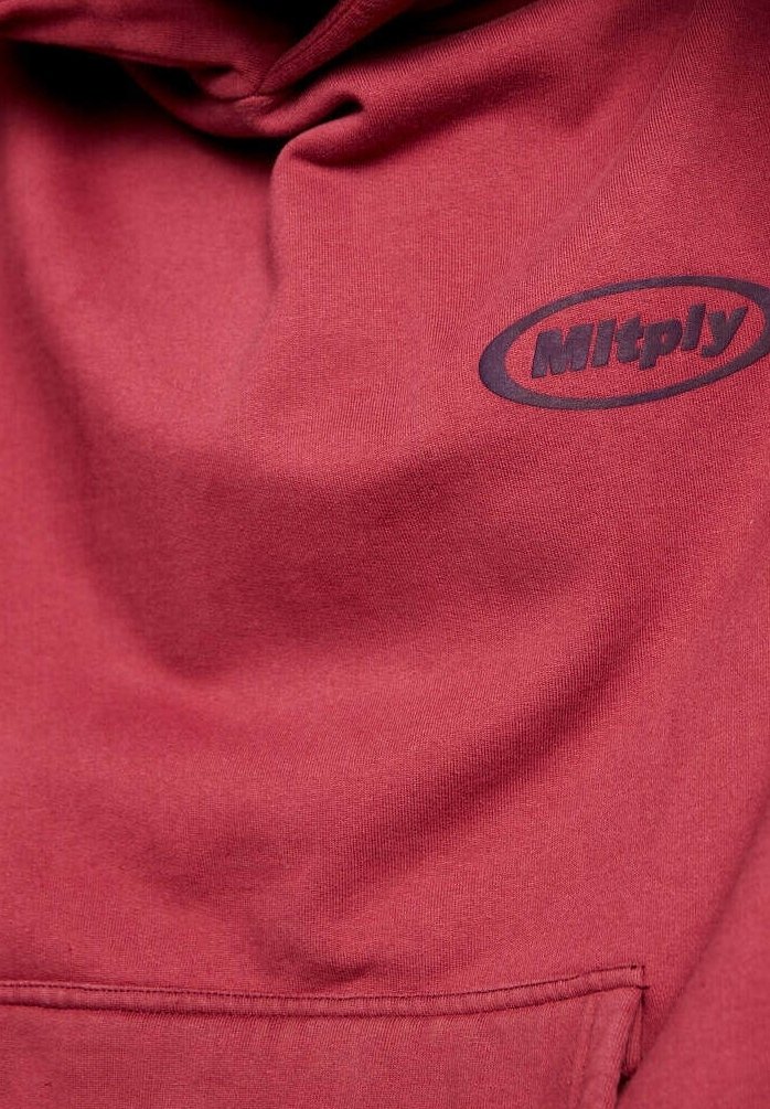 Czerwona bluza z kapturem wykonana z bawełnianej mieszanki tkanin, z przednią kieszenią oraz czarnym, zaokrąglonym logo na piersi. Gładka tekstura.