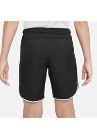 Shorts de sport noirs avec une texture légère et lisse. Présentent une bordure d'accent blanche le long de l'ourlet et une taille élastique.