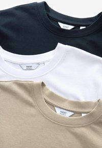 Drei Rundhalsausschnitt-T-Shirts in Marineblau, Weiß und Beige. Hergestellt aus weichem Baumwollmaterial, mit Etiketten und einem Regular-Fit-Design.