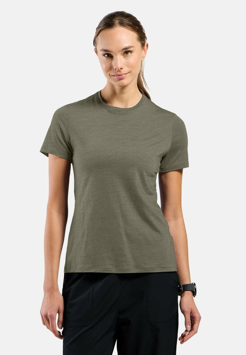 Short-sleeve, crew neck t-shirt in olive green, featuring a smooth texture and a relaxed fit, paired with black pants.