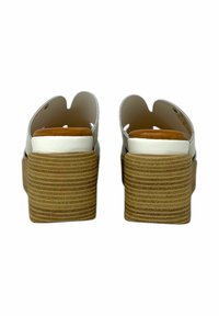 Sandali bianchi aperti sul retro con punta arrotondata, piattaforma a strisce marroni e finitura liscia e lucida. Soletta imbottita per il comfort.