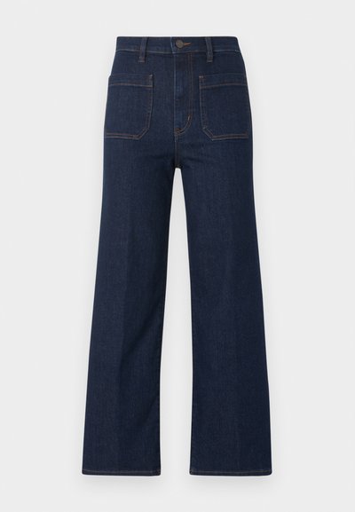 Σκούρο μπλε τζιν παντελόνι με φαρδιά γραμμή, ψηλή μέση, δύο μπροστινές τσέπες με επιδιορθώσεις, θηλιές για ζώνη και κλείσιμο με κουμπί εμπρός.