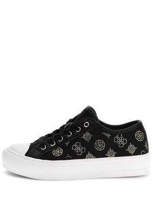 Czarny niski sneaker z białą gumową podeszwą i czubkiem, ozdobiony srebrnymi ćwiekami i czarnymi sznurowadłami.