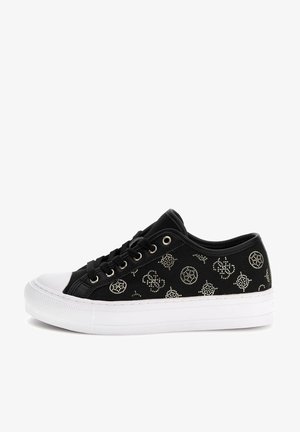 Czarny niski sneaker z białą gumową podeszwą i czubkiem, ozdobiony srebrnymi ćwiekami i czarnymi sznurowadłami.
