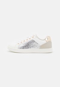 Vita sneakers med silverglittrande detaljer, en beige häl och roséguldssmycken. Har en slät yta och snörningsdesign.