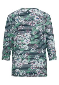 Oberteil mit floralem Muster, das auf einem dunkelblauen Hintergrund mit weißen und grünen Blumen gestaltet ist, akzentuiert durch horizontale Streifen. Dreiviertelärmel.