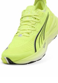 Scarpa da corsa verde lime con tomaia in rete, punta rotonda, suola testurizzata, dettagli neri e particolari riflettenti. Presenta chiusura con lacci.