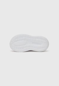 Semelle de chaussure en caoutchouc blanc avec surface texturée, présentant un motif de semelle pour l'adhérence et des zones lisses pour la flexibilité.