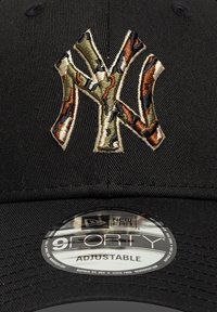 Μαύρο ρυθμιζόμενο καπέλο με κεντημένο λογότυπο "NY" παραλλαγής στο μπροστινό μέρος. Κατασκευασμένο από ύφασμα με δομημένο σχέδιο και καμπυλωτό γείσο.