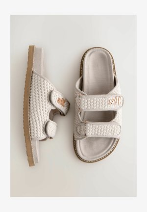 Szare klapki z teksturowaną cholewką, dwiema regulowanymi paskami oraz gumową podeszwą. Posiadają różowo-złote logo na paskach.