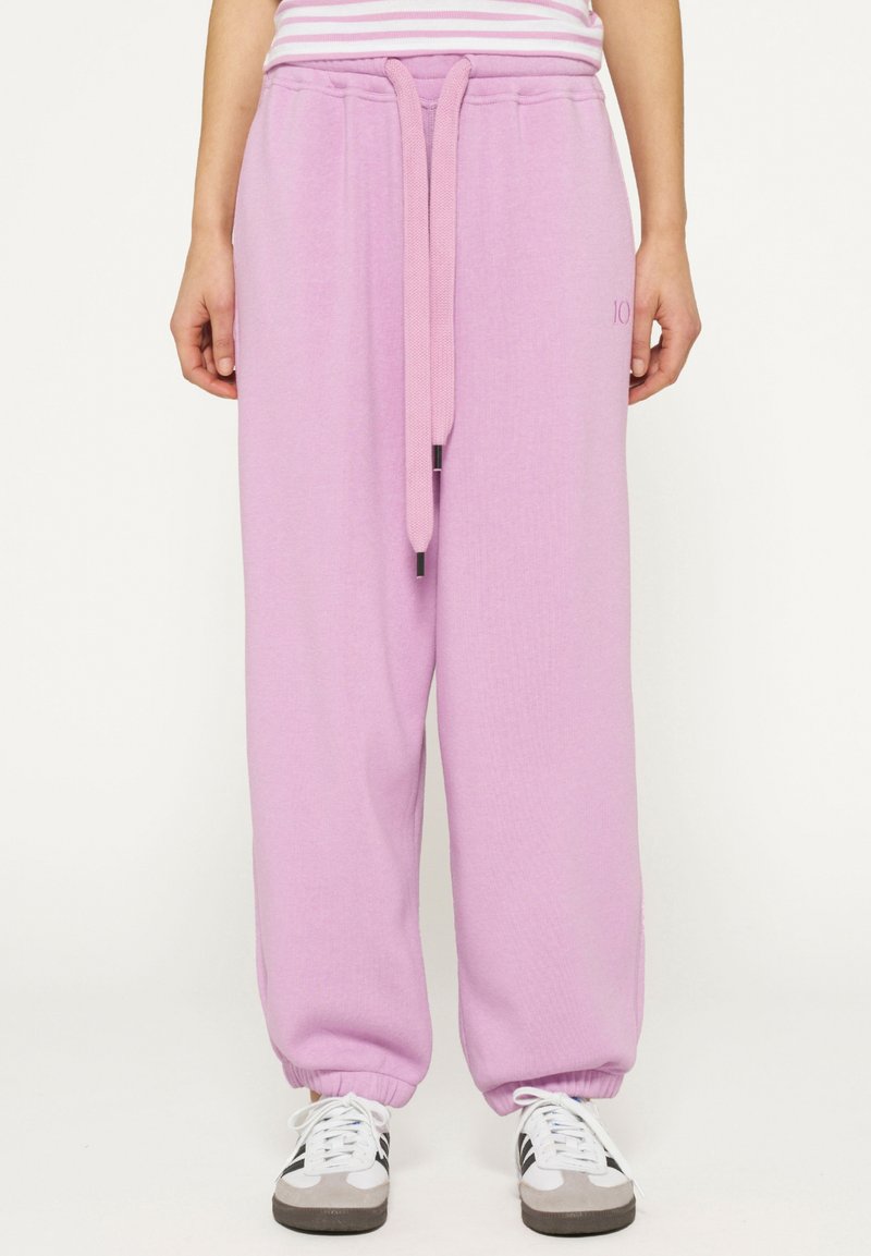 Lichtroze, losse sweatpants met een elastische tailleband, koord en boorden. Geweven stof met zijborduursel.