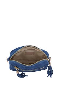 Niebieska zamszowa torebka typu crossbody z złotym zamkiem, jasnobrązowym wnętrzem i chwostami. Zawiera jedną główną komorę oraz małą kieszeń na zamek w środku.