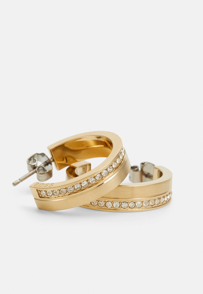 Boucles d'oreilles en or en forme de créole avec une surface lisse, ornées de strass transparents le long du centre, dotées d'un système de fermeture à clou.