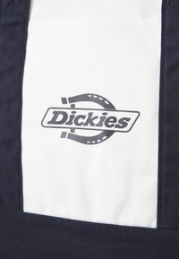 Tamsiai mėlynos ir baltos drobės audinys, turintis apvalų logotipą su žodžiu "Dickies" centre, supašytą taškine kompozicija.